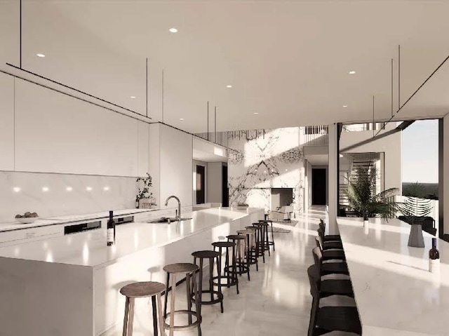 kitchen featuring white cabinets, a kitchen bar, decorative light fixtures, and sink