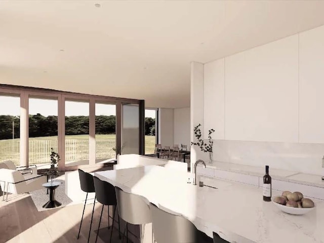 kitchen with a kitchen breakfast bar and white cabinetry