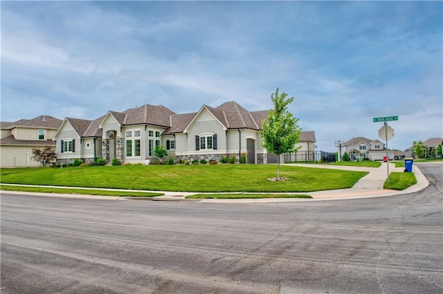 french country inspired facade with a front yard