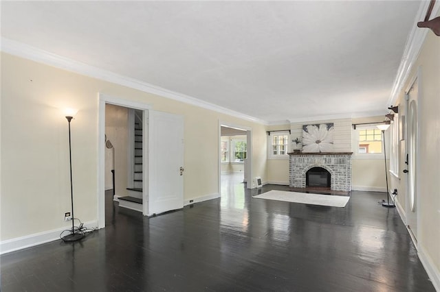 unfurnished living room featuring a fireplace, dark hardwood / wood-style floors, a wealth of natural light, and crown molding