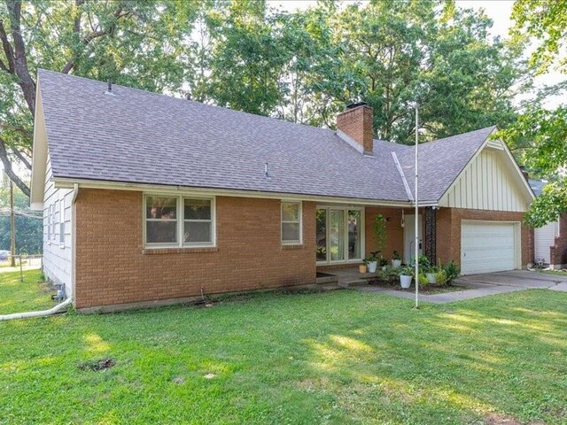 ranch-style home with a garage and a front yard