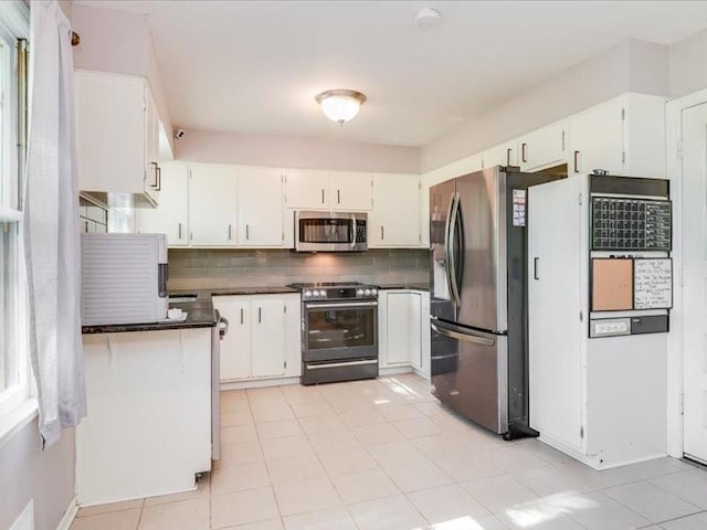 kitchen featuring white cabinets, appliances with stainless steel finishes, and tasteful backsplash