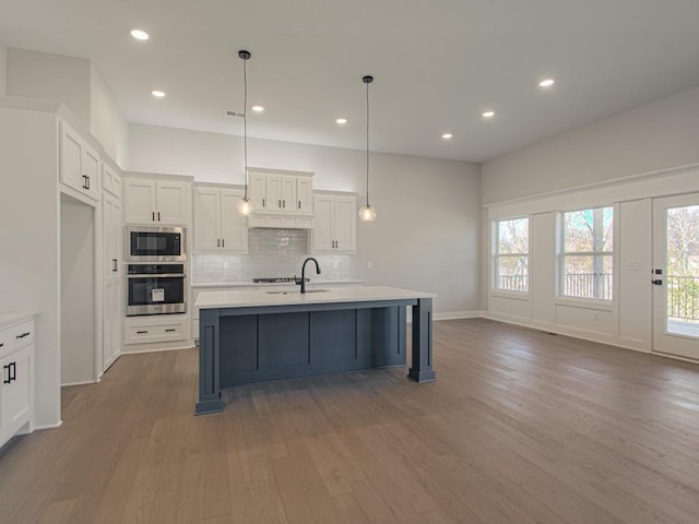 16430 NW 123rd St, Platte City, MO 64079 - kitchen with built in microwave, wood finished floors, oven, white cabinetry, and light countertops