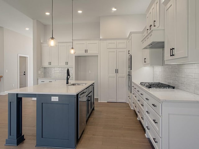 kitchen featuring sink, white cabinetry, hanging light fixtures, and light hardwood / wood-style floors