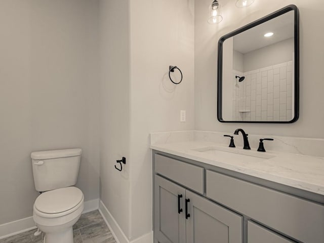 bathroom featuring vanity, toilet, and a shower