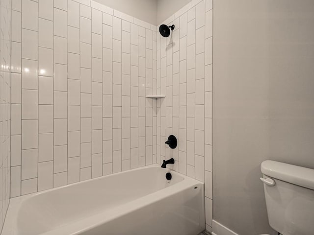 bathroom featuring toilet and tiled shower / bath