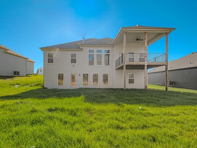 back of house featuring a lawn and ceiling fan