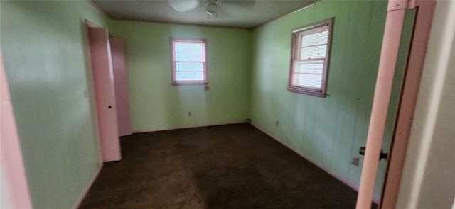 unfurnished bedroom featuring ceiling fan and dark carpet