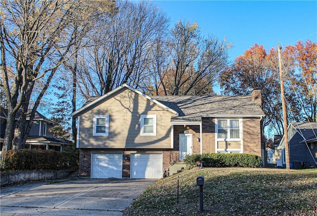 split foyer home featuring a garage and a front yard