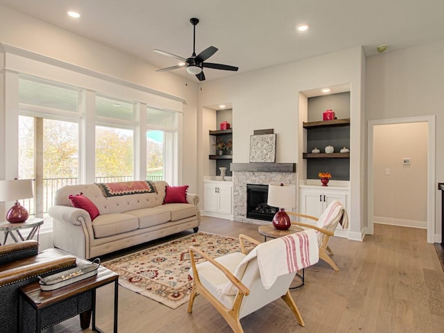 12435 Appaloosa St, Platte City, MO 64079 - living room with ceiling fan, built in features, light wood-style floors, a fireplace, and recessed lighting
