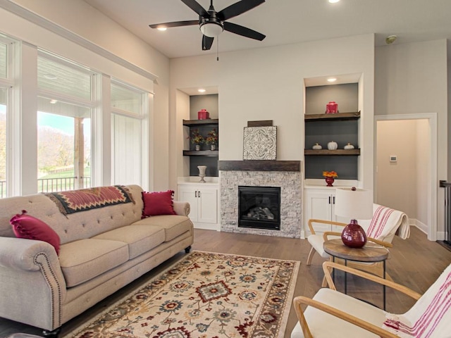 12435 Appaloosa St, Platte City, MO 64079 - living area with a ceiling fan, built in features, wood finished floors, and a stone fireplace