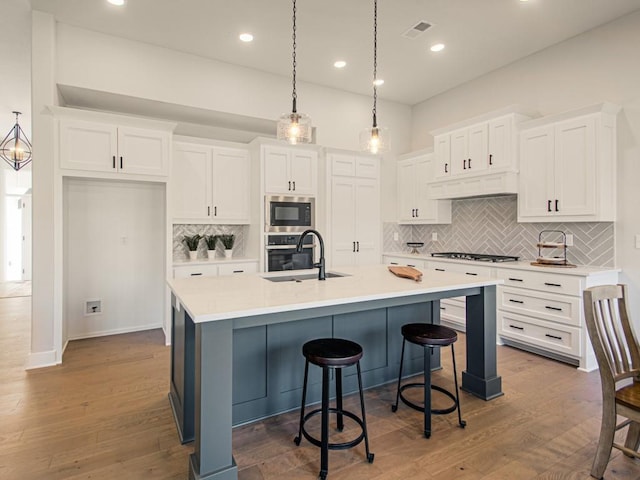 12435 Appaloosa St, Platte City, MO 64079 - kitchen with appliances with stainless steel finishes, a sink, white cabinets, tasteful backsplash, and light countertops