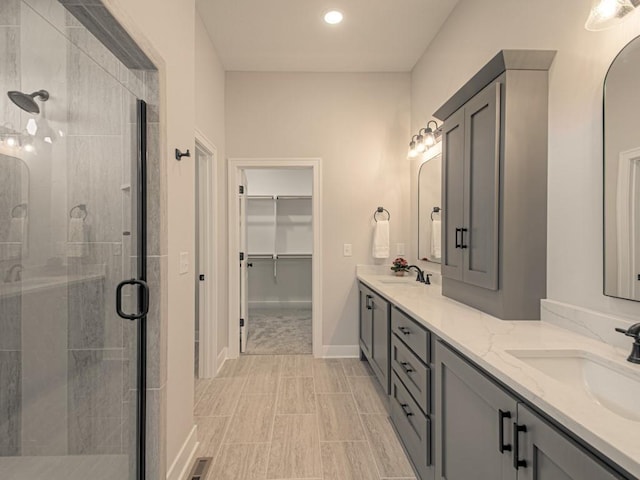 12435 Appaloosa St, Platte City, MO 64079 - full bathroom featuring a shower stall, double vanity, a spacious closet, recessed lighting, and baseboards