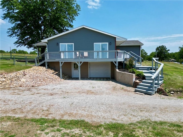 view of front of home featuring stairway, driveway, a wooden deck, and an attached garage