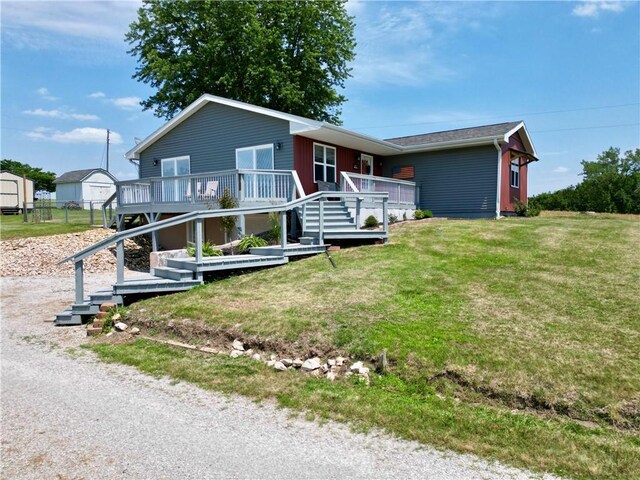 single story home with a deck, a front yard, and stairs