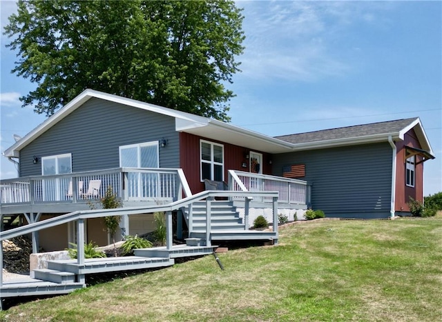 rear view of property featuring a yard, a wooden deck, and stairs