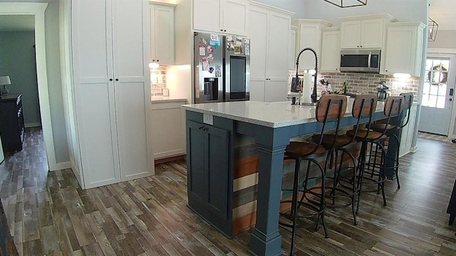 kitchen featuring dark wood finished floors, appliances with stainless steel finishes, white cabinetry, and light countertops