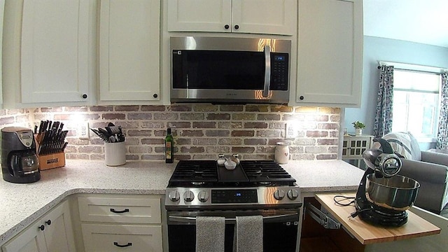 kitchen featuring decorative backsplash, light countertops, and stainless steel appliances