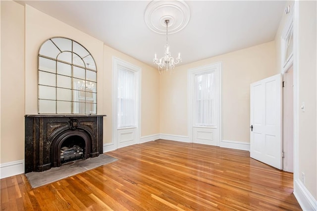 unfurnished living room with wood-type flooring and a chandelier