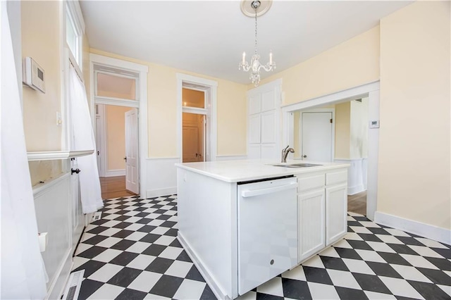 kitchen featuring sink, an inviting chandelier, decorative light fixtures, white dishwasher, and white cabinets