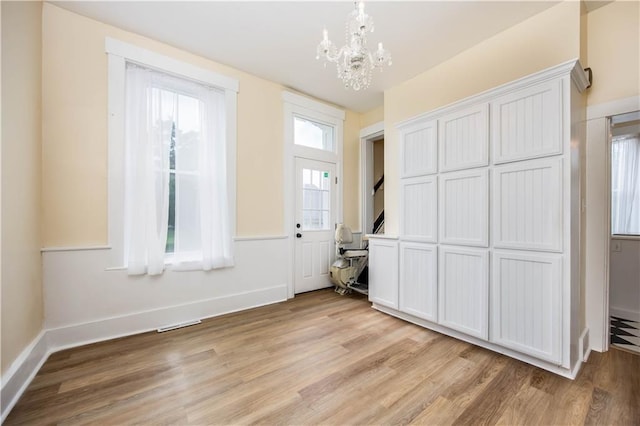 interior space with a notable chandelier and light wood-type flooring