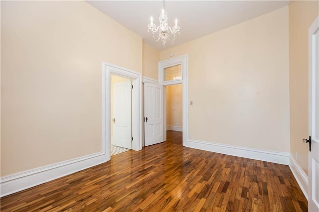 unfurnished room with dark hardwood / wood-style floors and a chandelier