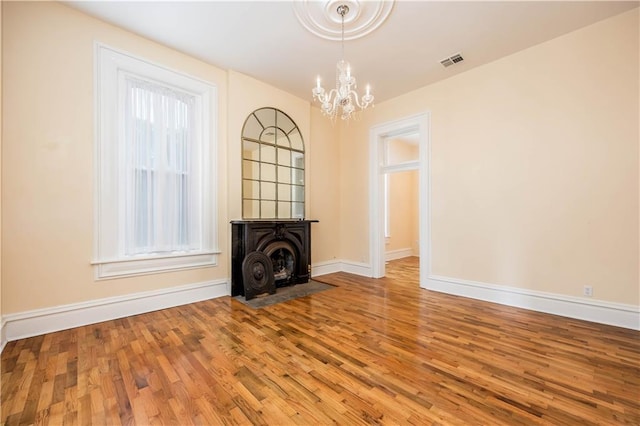 unfurnished living room with hardwood / wood-style flooring and an inviting chandelier