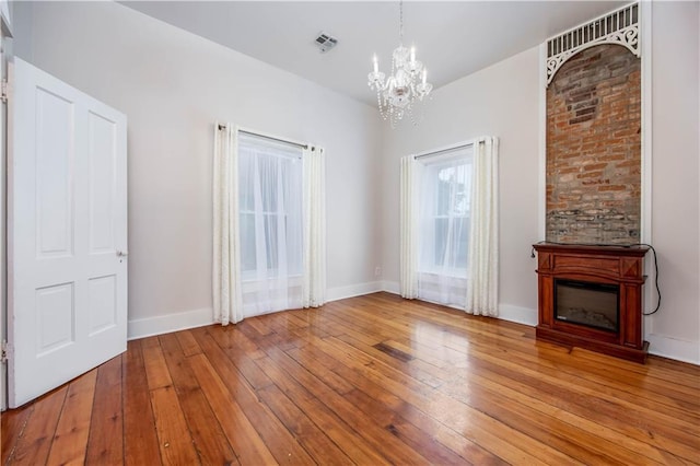 unfurnished living room with hardwood / wood-style flooring and a chandelier