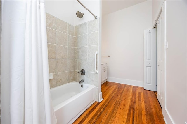 bathroom with hardwood / wood-style flooring and shower / bath combo with shower curtain