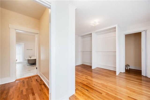 corridor with hardwood / wood-style flooring