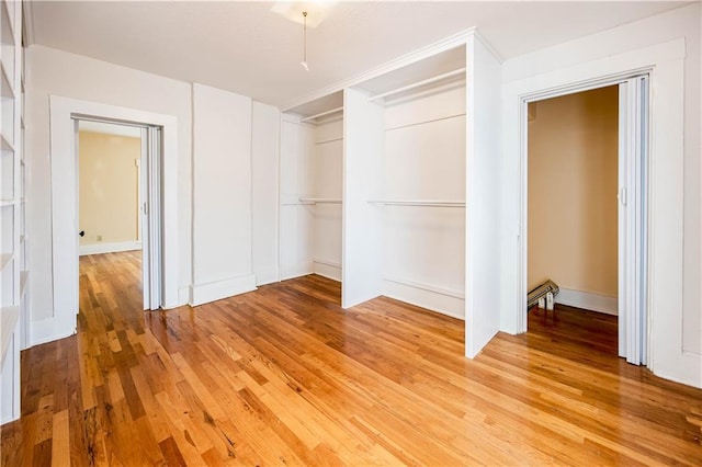 unfurnished bedroom with wood-type flooring and a closet