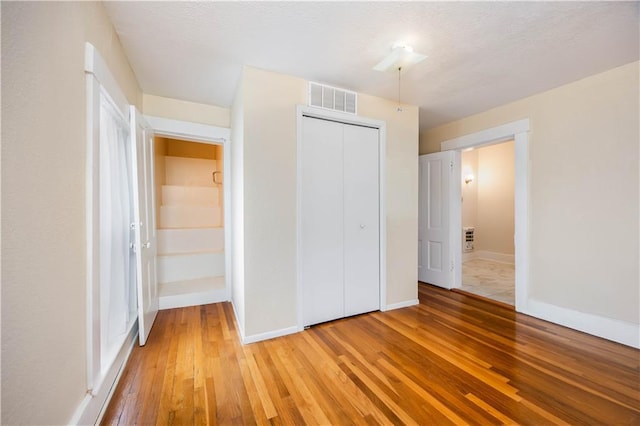 unfurnished bedroom featuring wood-type flooring and a closet