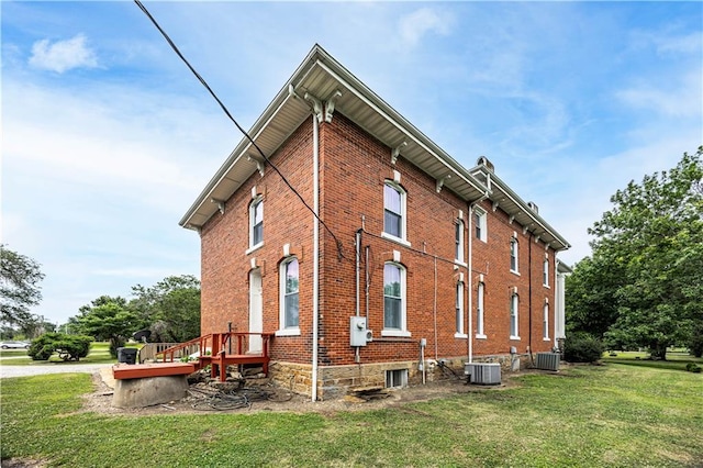 view of property exterior with a yard and central AC