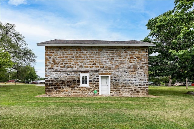 view of outbuilding featuring a yard