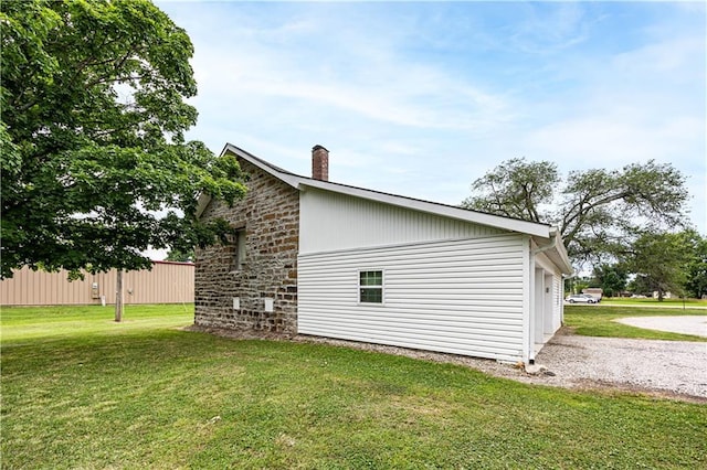 view of property exterior featuring a garage and a lawn