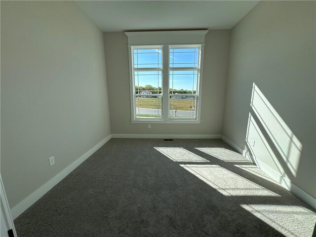 empty room featuring dark carpet