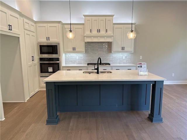 12710 NW Bittersweet Dr, Platte City, MO 64079 - kitchen featuring a kitchen island with sink, backsplash, stainless steel appliances, and dark wood finished floors