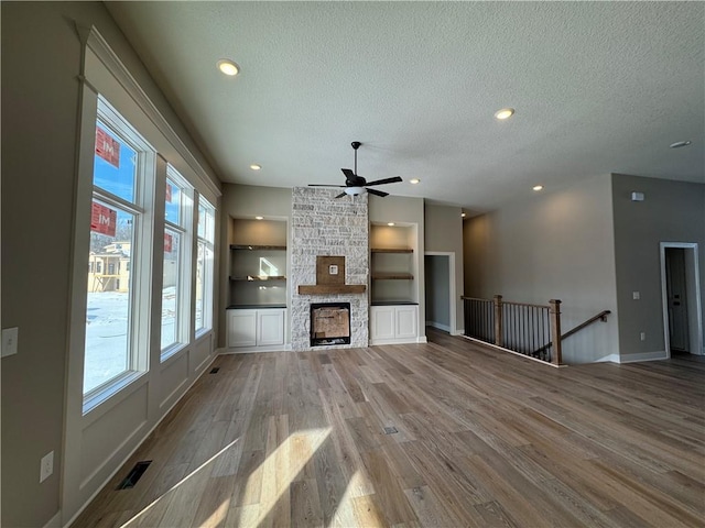 13503 NW Terrace Park Dr, Parkville, MO 64152 - unfurnished living room with visible vents, a ceiling fan, light wood-type flooring, and a textured ceiling