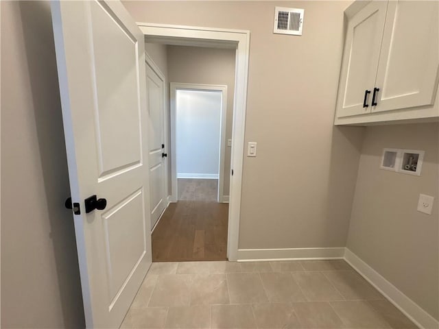 clothes washing area featuring washer hookup, cabinets, and light hardwood / wood-style flooring