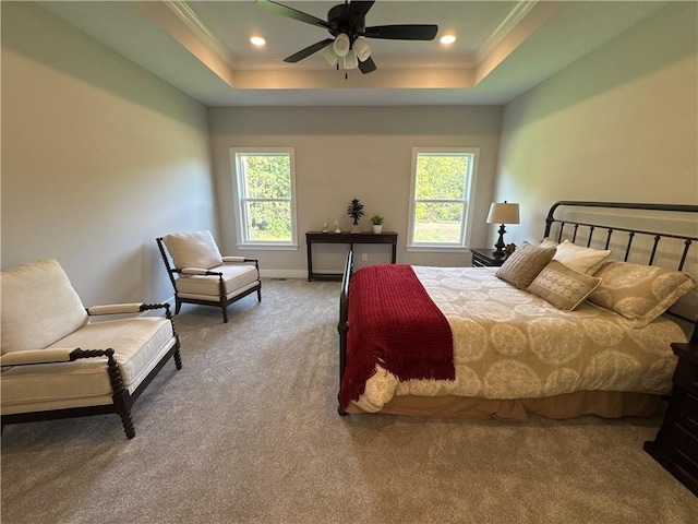 bedroom with multiple windows, a raised ceiling, and ceiling fan