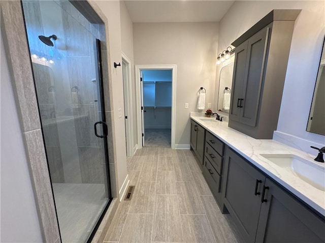 bathroom with a shower with door and vanity