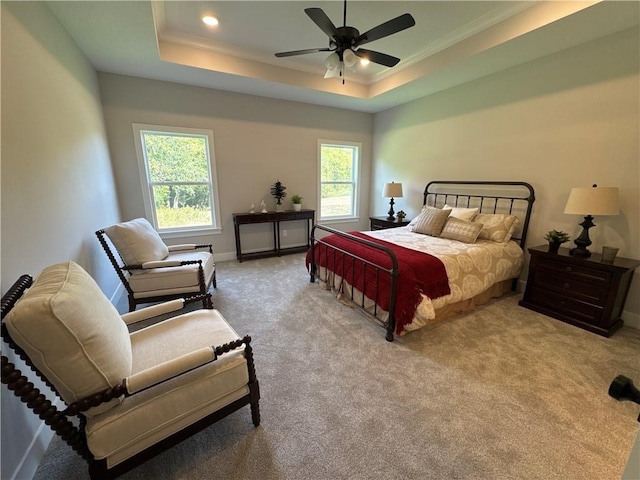 bedroom featuring a raised ceiling, ceiling fan, light colored carpet, and ornamental molding