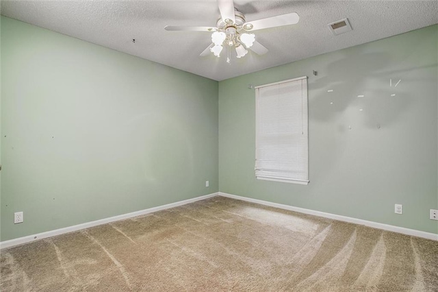 carpeted empty room featuring ceiling fan and a textured ceiling