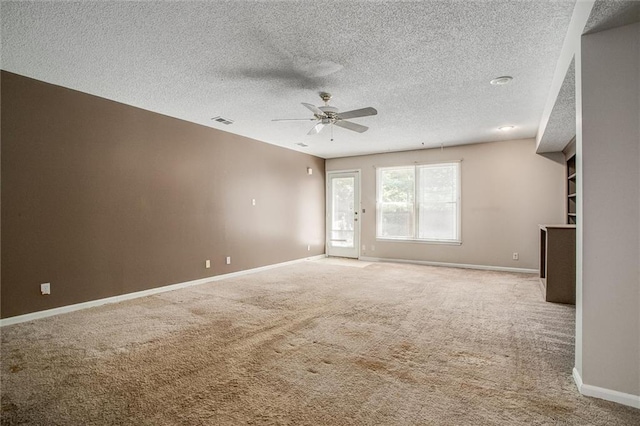 empty room featuring carpet flooring, ceiling fan, and a textured ceiling