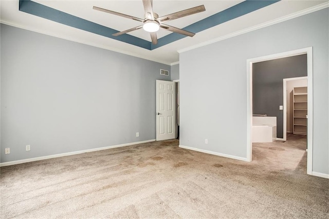 unfurnished bedroom with light carpet, a raised ceiling, a walk in closet, ceiling fan, and a closet