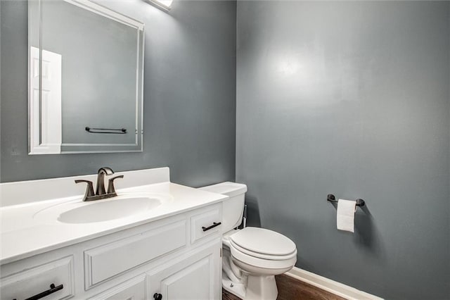 bathroom with hardwood / wood-style flooring, vanity, and toilet