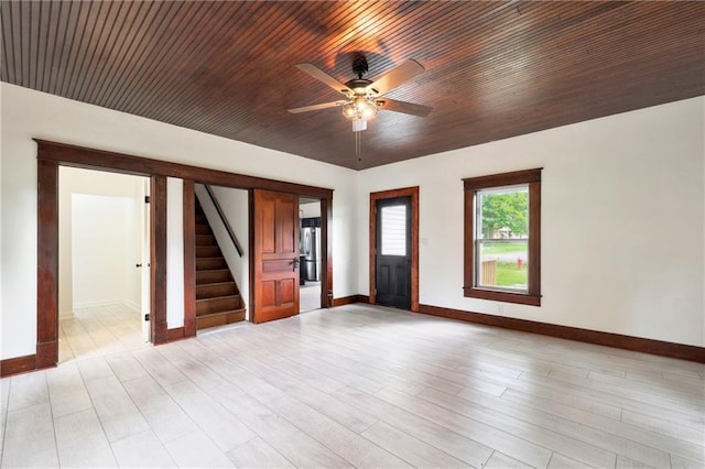 empty room with ceiling fan, light wood-type flooring, and wood ceiling