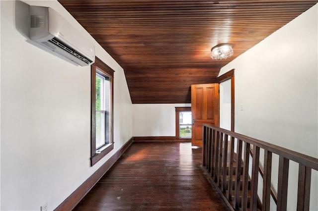 hall with a healthy amount of sunlight, dark hardwood / wood-style floors, a wall mounted AC, and wooden ceiling