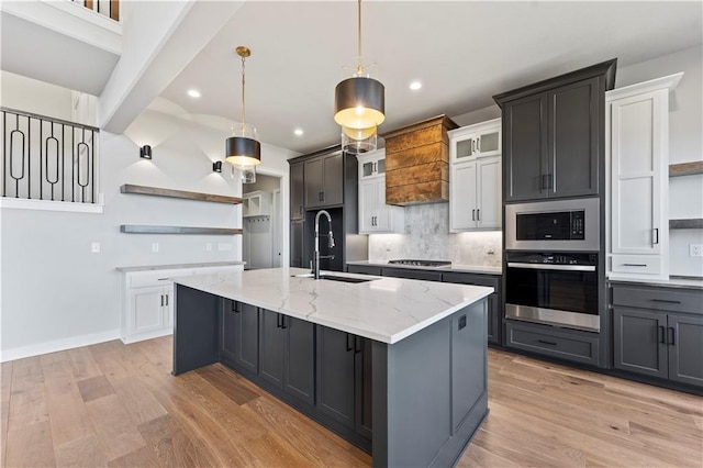 kitchen with white cabinetry, sink, stainless steel appliances, a spacious island, and pendant lighting