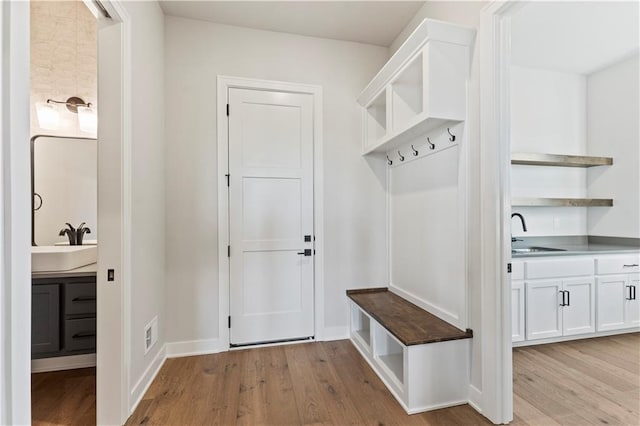 mudroom with light hardwood / wood-style floors and sink